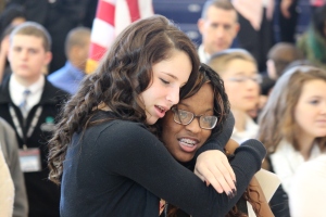 Ninth graders Saige Grace-Lange and Nakia Junor share a hug as they celebrate a permanent home for their school.